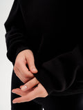 a close up of a person wearing a black sweater