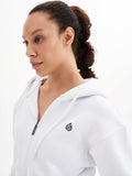 a woman wearing a white jacket and a ponytail