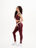 a woman in a maroon sports bra top and maroon leggings