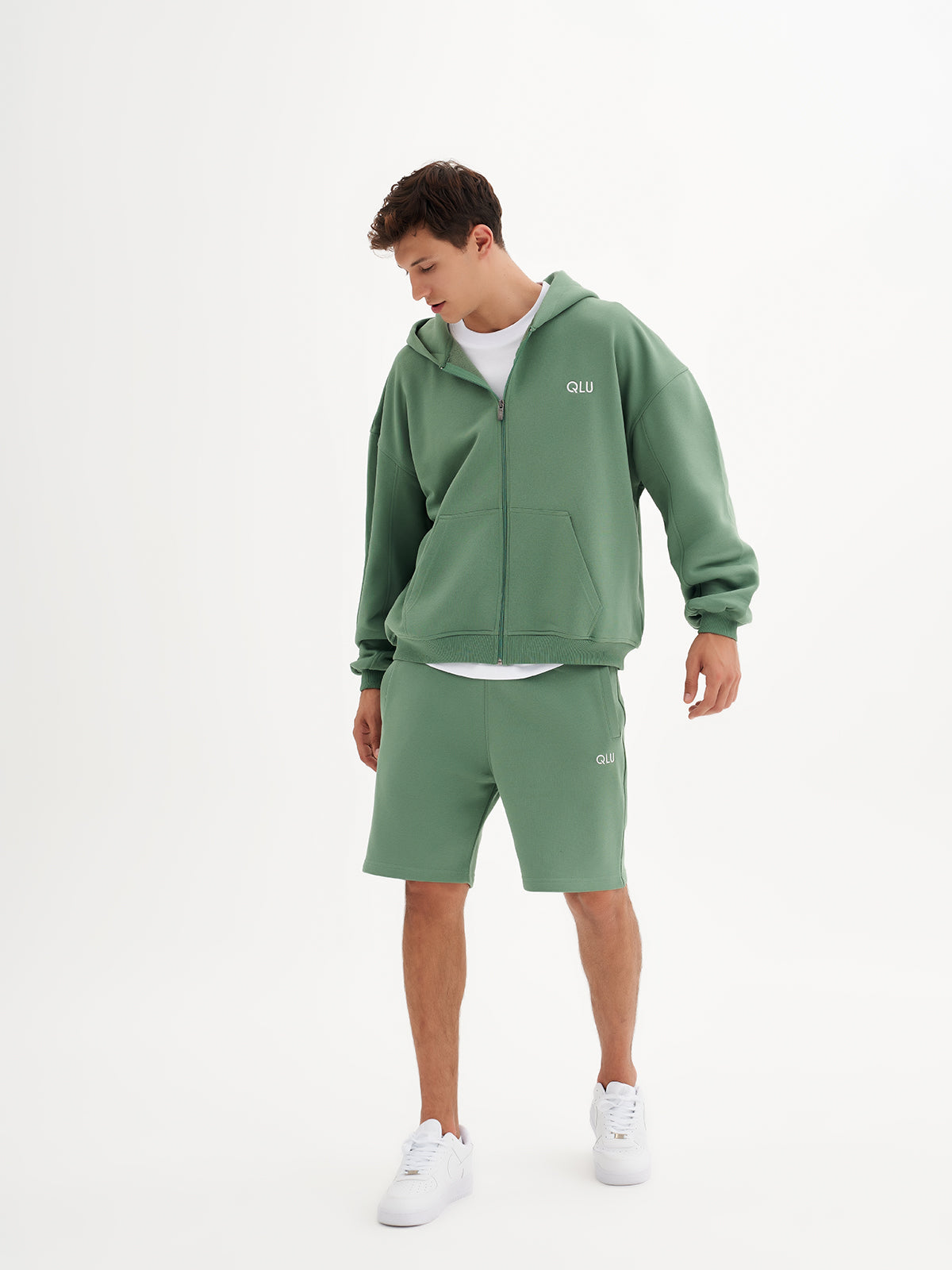 a man in a green hoodie and shorts