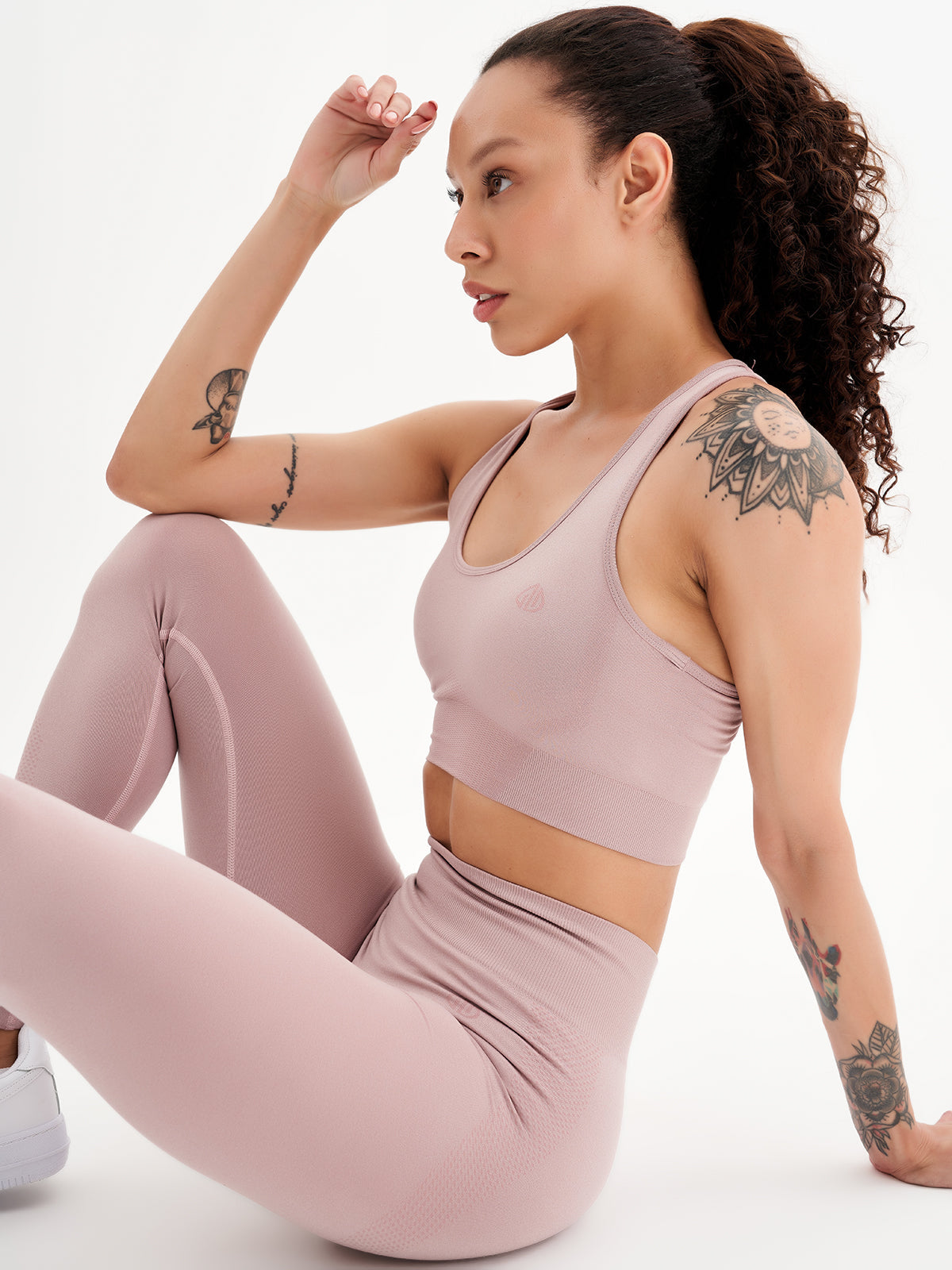 a woman sitting on the ground in a pink outfit