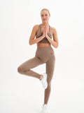 a woman standing in a yoga pose with her hands in the air