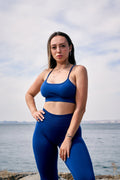 a woman in a blue sports bra top and leggings